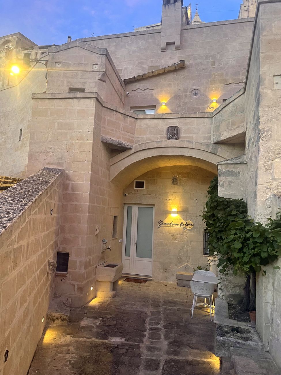 L'ingresso di Giardini di Luce, arco in pietra illuminato di sera